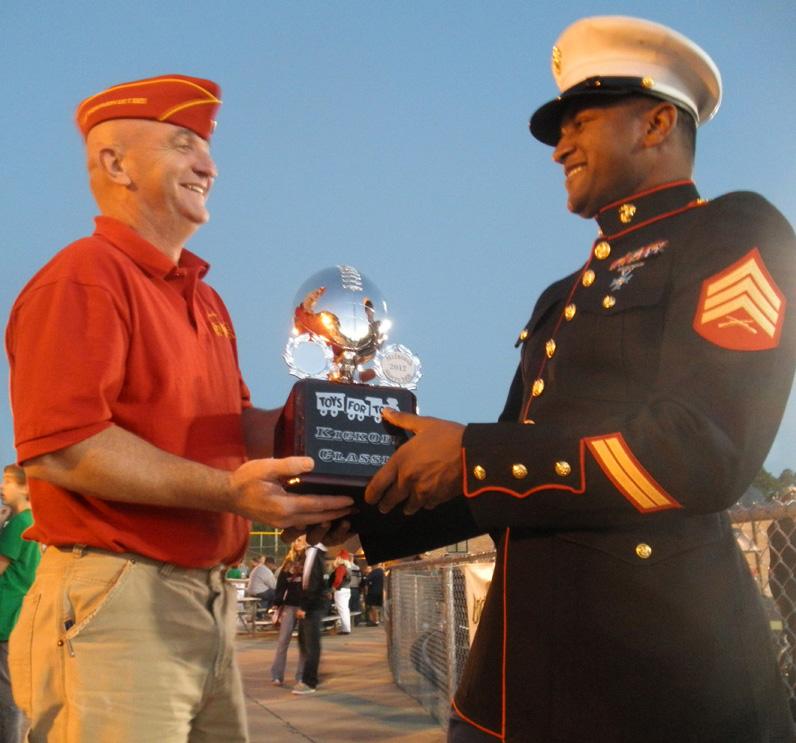 Jeff White hands off the trophy to Sergent Buchana to present to the winning school at the end of the third quarter. 