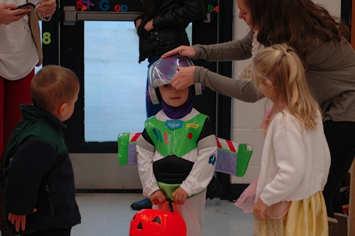 The preschoolers are ready to begin their trek around the school, armed with their candy holders and costumes. 
