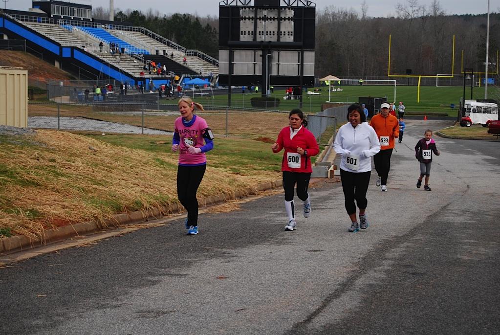 Special education teacher Jenny Kelly, office secretary Angela Goddard, and Ingird Zambrana, mother of junior Jazmin Zambrana, run up a hill from Panther Stadium soon after the beginning of the race.  