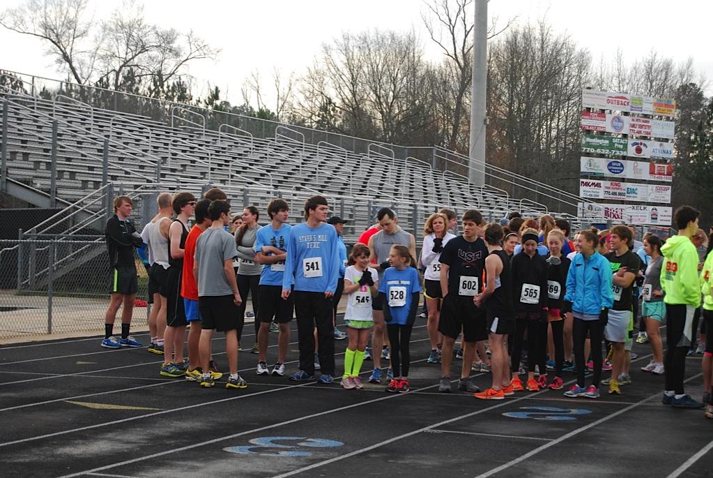 Over 100 runners bounce on the start line waiting for the gun to go off and start the 5-kilometer race. 