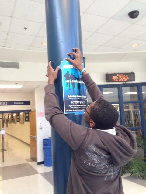 Senior track and field runner Timmy Roberts hangs up posters advertising the Panther Prowl 5-K race, which will be held Saturday, Jan. 26, at Panther Stadium. 