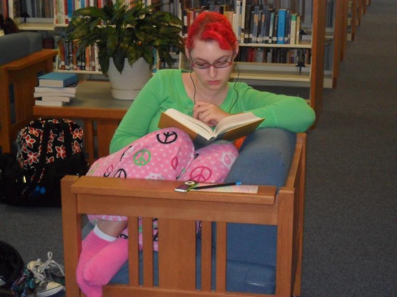 Senior Abby Smith, in her fuzzy pink pajama pants, curls up in a chair with a good book and a set of headphones.