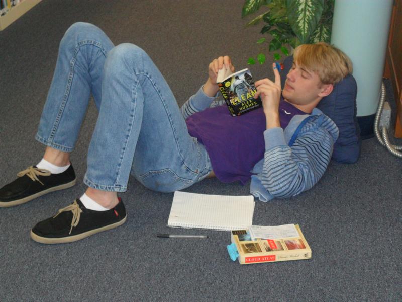 Enthralled by the unconventional plot of the story, senior Jake Troyer  reads Alex Hughes' new thriller, "Clean," at the Ex Libris Book Club's annual Read-a-Thon.