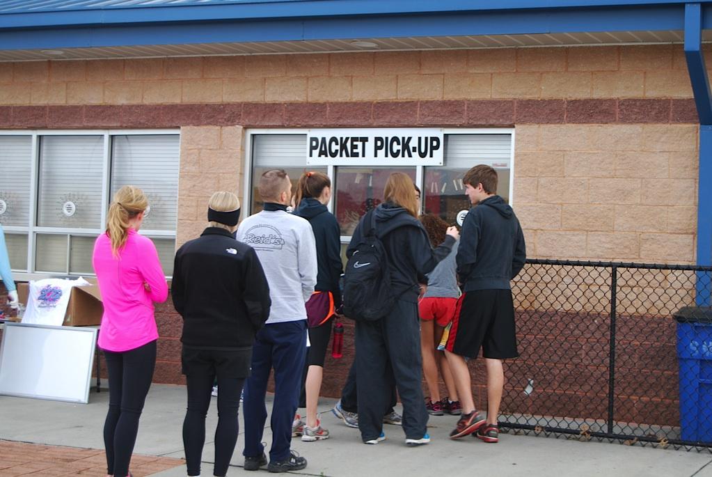 Runners wait in line to pick up their race packets, containing their race number, T-shirt, and advertisements from sponsors. 