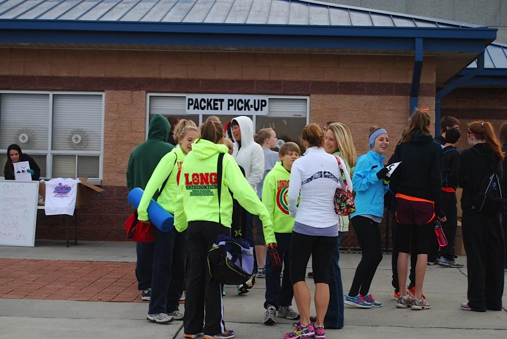 Before the race, runners stand in tight groups to keep warm until it is time for their race to begin. 