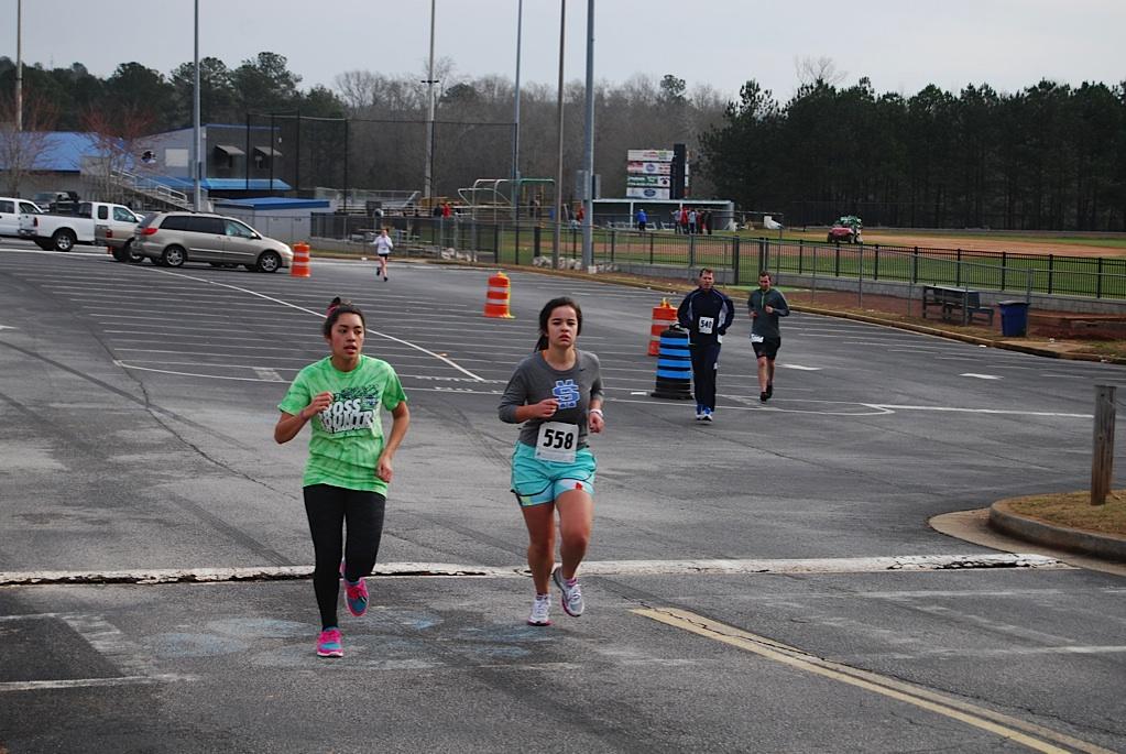 Junior Jazmin Zambrana and sophomore Ana Bankey keep each other company during the 5-kilometer race by talking to each other. 