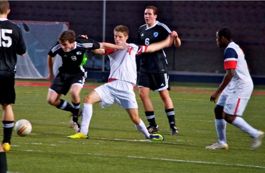 Senior Kyle Ulversoy (left) fights off a Creekside forward to win back the ball during their win Tuesday night. 