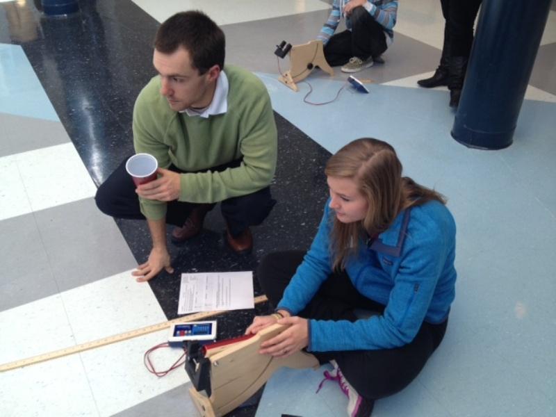 Ryan Mewborn teaches his physics students about projectile motions by doing a marble launching lab in the rotunda. Students practiced launching marbles at different trajectories and recorded how far each marble traveled. 