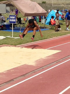 Freshman Alexis Farley flies through air as she jumps 36-11 in the triple jump to break her own school record. 