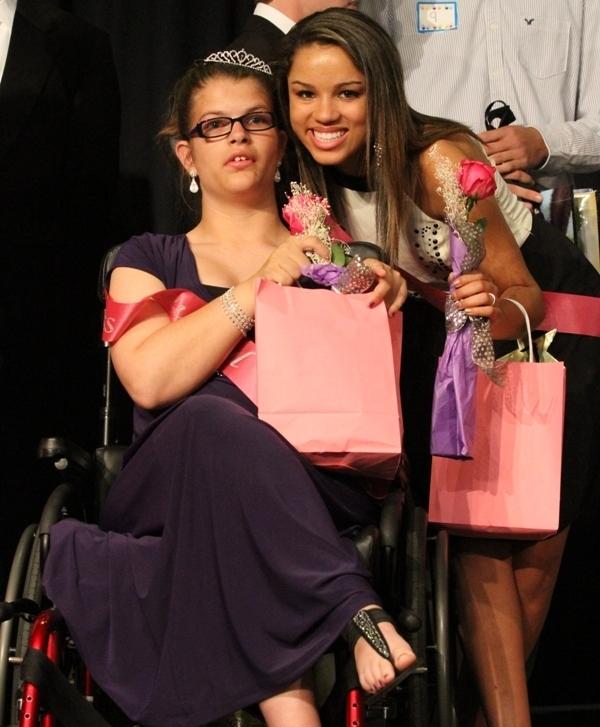  With their pink goodie bags in hand, sophomore Lauren Ladouceur grabs a photo with junior Corrie Williamson at the end of the pageant.