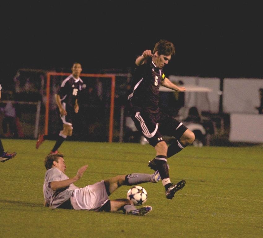 Senior Patrick Spencer avoids a vicious slide tackle from a Northside Columbus Patriot forward in their first round  10-0 win. 