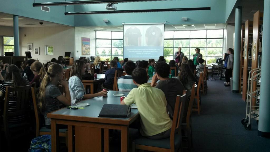 Members watch the officers present the schedule and the T-shirt designs for this year.