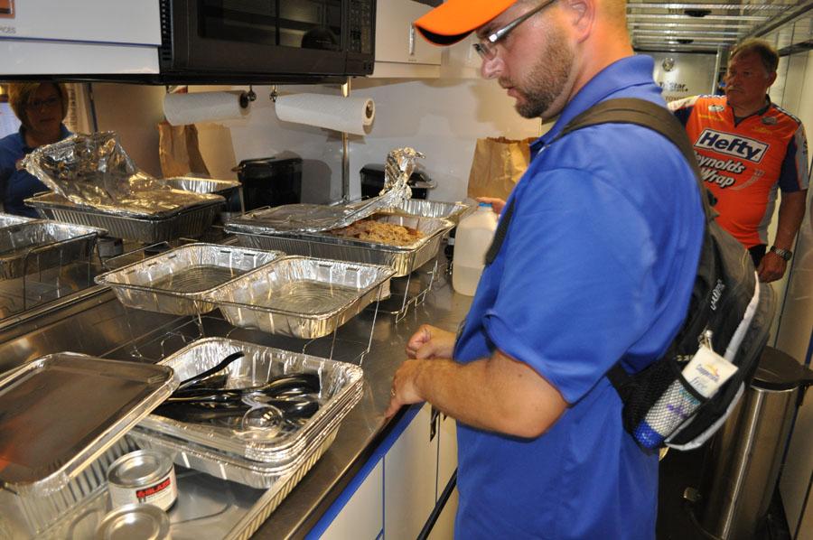 Justin Spencer arranges several trays of food inside the Hefty trailer as he prepares to serve the crew lunch.