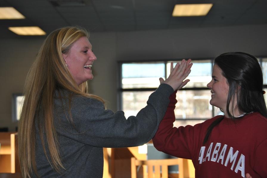 Ashley Powers (left) and Molly Moroney high-five each other after they signed their contracts for Emory and Alabama. 