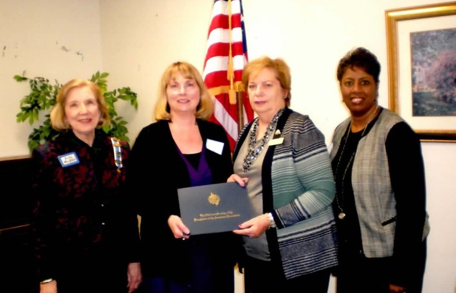 DAR Regent Judy Hughes (left) and DAR Historian Linda McBride (second from right) present Charlotte Robinson with the Outstanding Teaching Award. Starrs Mill Principal Audrey Toney attended the ceremony at the Peachtree City Library. 