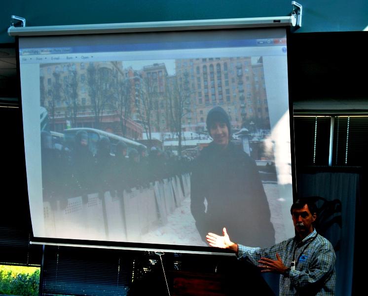 Scott Ash shows the students gathered in the Media Center his sons Facebook profile picture. Aaron is standing in front of a line of riot police in Maidan Square in Kiev. 