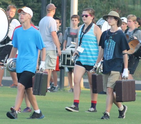 Businessmen Ryan Bohdan, McKenzie Artman and Kyle Wegner walk onto the field in character as a part of the intro of When I met you.