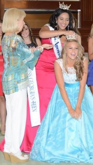 Abby Feltner smiles brightly as she receives her new crown from the former state title holder Olivia McMillan. 