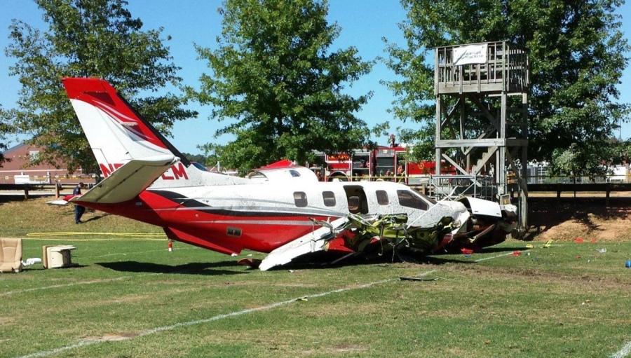 The turboprop TBM850 lays on the ground  after crash-landing on the marching band's practice field. 