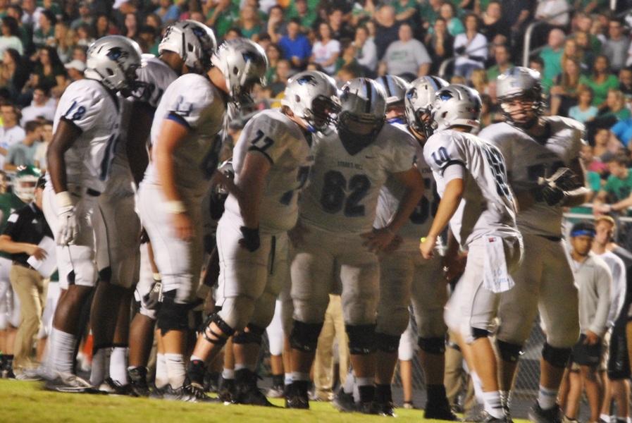 Sophomore quarterback Stone Kasten speaks to his offense in the huddle during the second quarter of the Panthers win over Mcintosh.