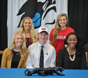 Natalie Orcutt (from left), Megan Binkley, Adam Goodman, Rachel Williams, and Danielle Ajayi gather in the Media Center to sign their letters of intent with their colleges.