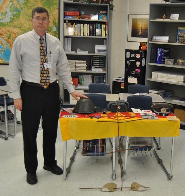 Substitute teacher and former Army veteran Michael Stacey stands next to some Cold War items he brought in for a History lesson he presented to the students in Rebecca Rickeards Word History and AP Euro classes the day before Veterans Day. 