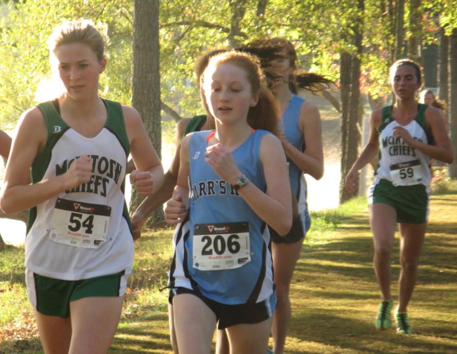 Freshman+Mary+Valli+leads+in+front+of+the+pack+of+runners.+She+goes+on+to+win+the+race+and+be+the+region+individual+champion+alongside+senior+Josh+Warren.++