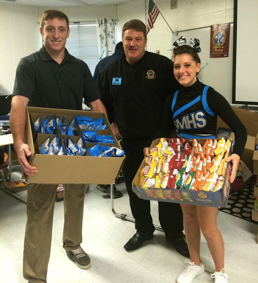 Juniors Nathan Cockes and Olivia East receive a 
surprise treat from Frito-Lay representative Dan Shanko after his visit to their classroom.  