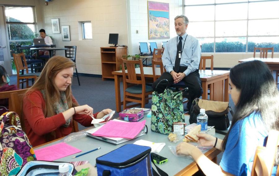 Juniors Ellie Hagen (left) and Alyssa Olvera eat their lunches and listen to author Kelly Baker talk about his book My Name is Lazarus and give writing tips. 