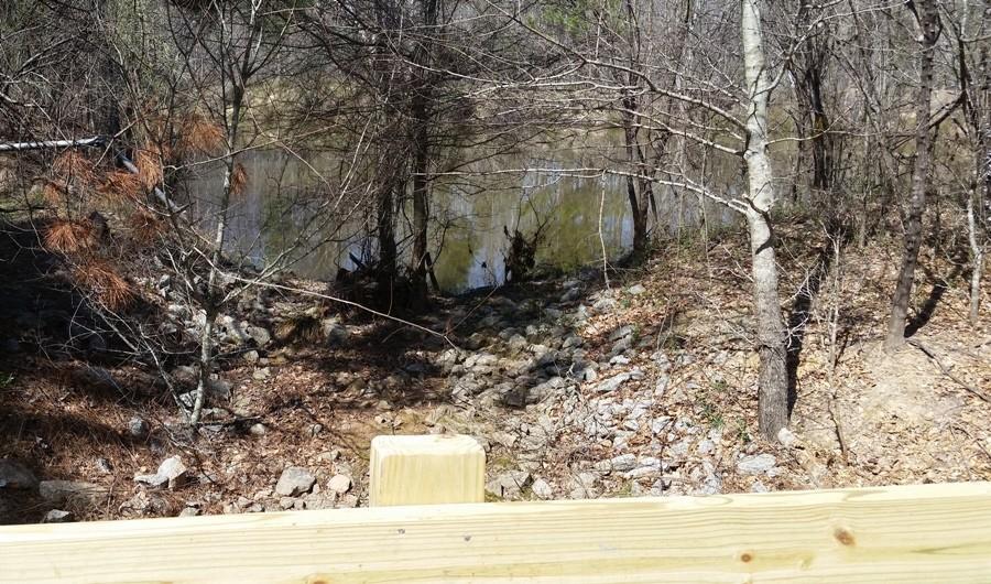 A bridge connects across a small reservoir close to the back of the parking lot. 