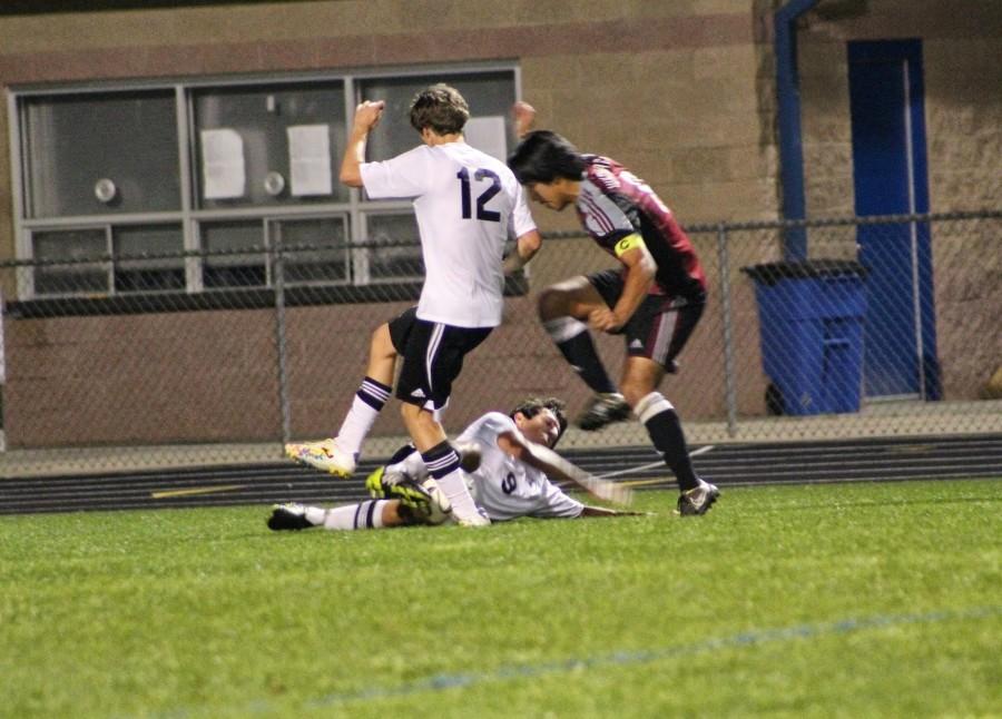 Seniors Tyler Annis (12) and Armon Varmeziar (9) draw a tackle to challenge the Whitewater midfielder before he could shoot on goal. 