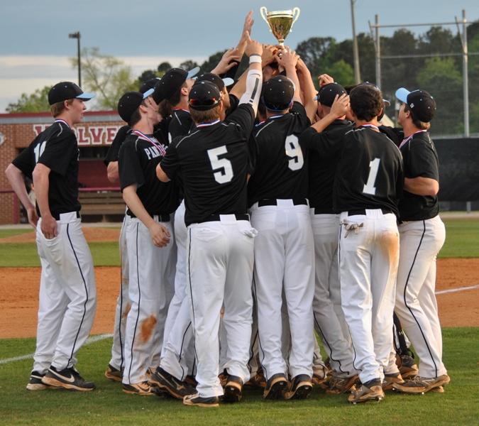 The Panthers huddle around the Region 4-AAAAA Championship trophy after their 5-4 win over Union Grove last Thursday. It is the sixth time the school has won the trophy.