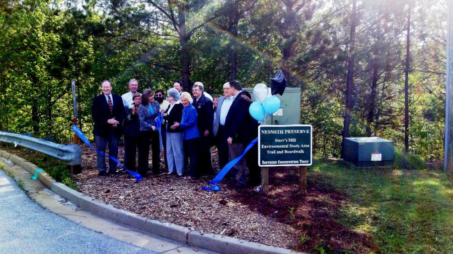 Fayette County Board of Education Chair Marion Keys snips the last ribbon to open the Southern Conservation Trust Nesmith Path as the finale to the opening of the multi-purpose cheer facility and the golf cart parking lot. 
