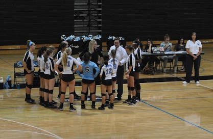 Volleyball coach Walt Ellison huddles with his team to discuss strategies during a time-out in their game against Northgate on Sept. 1.