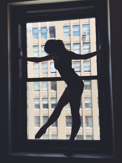 Junior Kayla Mapel strikes an artistic pose in a double-hung window the second day at Joffrey’s Jazz Intensive summer program in Pearl Studios before class begins. 