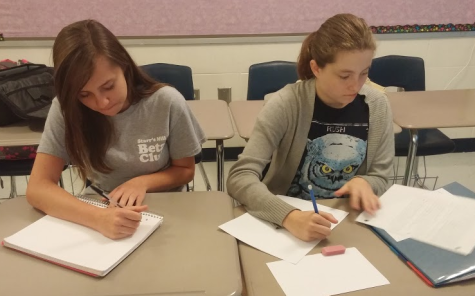 Sophomores Dana Gould and Ashton Long write their warm-up prompt for Jillian Bowen’s Advanced Creative Writing class.