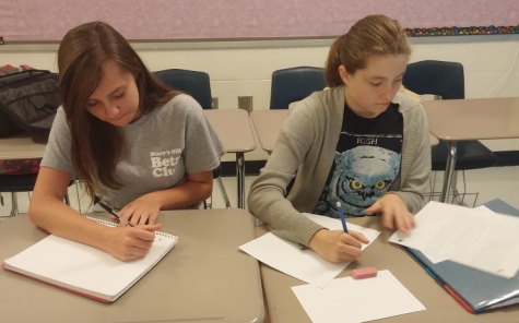 Sophomores Dana Gould and Ashton Long write their warm-up prompt for Jillian Bowen’s Advanced Creative Writing class. 