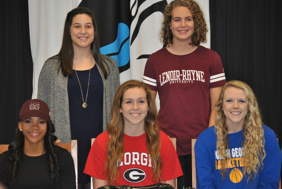 Five+Panther+athletes+smile+after+they+sign+their+college+letters+of+intent.+The+signing+took+place+at+9+a.m.+on+Nov.+12+with+parents%2C+coaches+and+administration+in+attendance.+