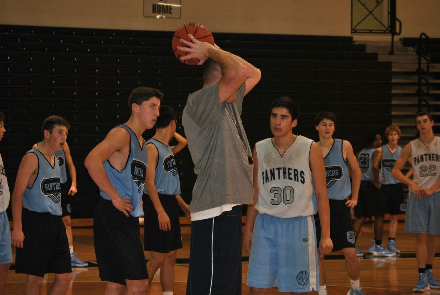 Head+coach+Brandon+Hutchins+explains+shooting+techniques+and+basketball+strategies+to+his+players.+