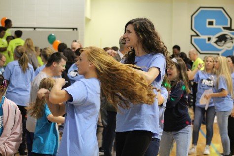 Students volunteers at Special Olympics dance in the gym before the basketball games begin.