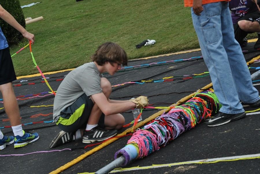 Oct. 24, 2015 - Students unroll the pipe cleaners and tape them down to the track so that the pipe cleaners stay in place.