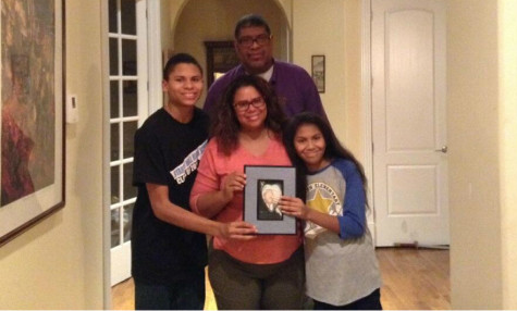 Freshmen Jacob Just-Buddy and his family pose with pride holding a photo of Buddy Just-Buddy, the first to use their unique last name.