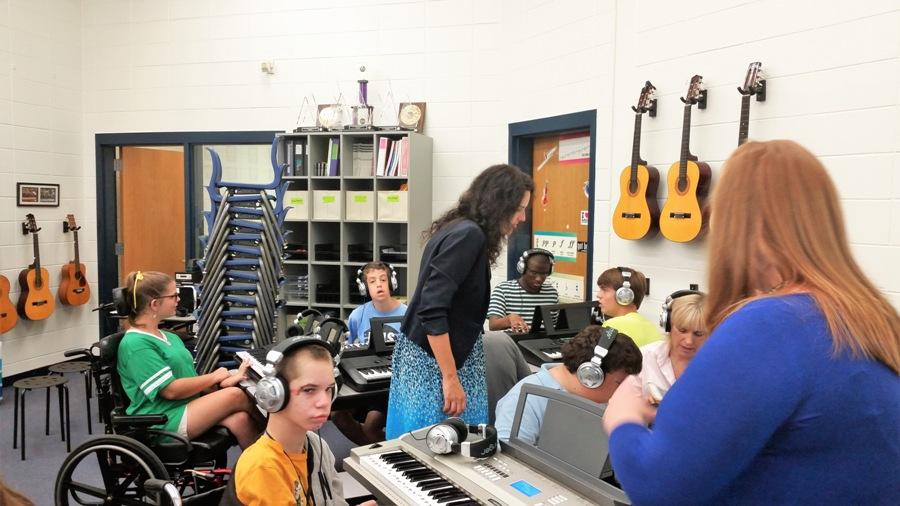 Middle school chorus teacher Christy Todd and adaptive curriculum specialist Courtney Savage assist the students in playing piano. “Music is a huge part in the way I teach the curriculum,” Savage said.