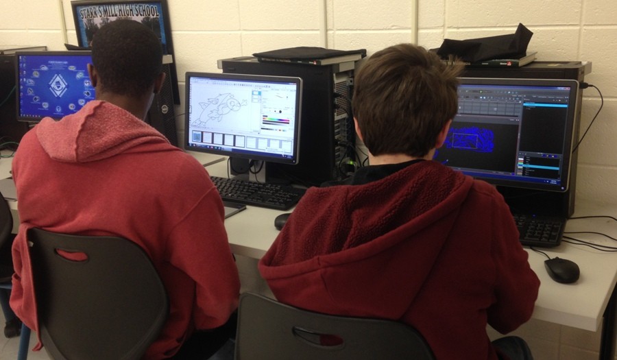 Junior Micah Stuart uses digital media software, Storyboard Pro, in the new Introduction to Digital Media class to design one of the scenes on his rendition of the children's book “Jeremy Fisher.” Next to him, senior Dawson Bassan works with the second-year Harmony software after completing his assessment early. 