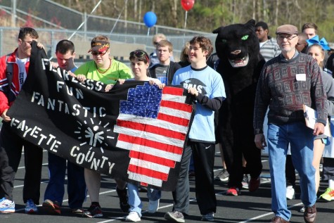 Special olympic alumni athletes lead the Special Olympics parade for the beginning of the opening ceremonies on March 23. During the parade, all schools were introduced while athletes, teachers and student volunteers walked once around the Panther Stadium track. 