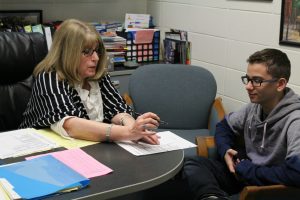 Dr. Sue Hutton helps a student register for his upcoming fall classes. The seven period day schedule has positively impacted students at the Mill, giving them numerous electives to choose from but has also forced teachers to make some changes in their lesson plans.