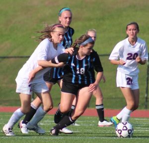 A Lady Panther soccer player fights for control of the ball as a Columbus player tries to grab her down. This was a common theme during the state semifinal match against Columbus. 