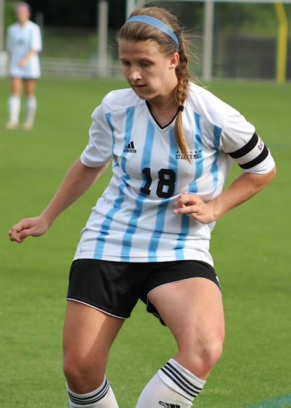 Girls soccer player dribbles the ball up field in a early round playoff game against Harris County. 