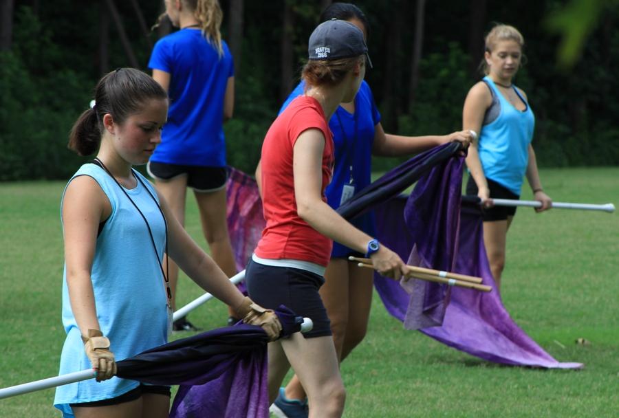 Color guard instructor Patti Morgan teaches a new flag routine to the guard members. The flags add a visual element to the show that helps capture the emotions. They use different colored and sized flags ranging from three to seven feet.