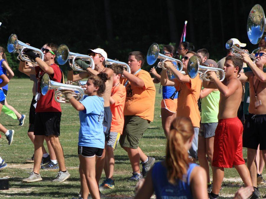 The+band+students+practice+this+year%E2%80%99s+show+after+school+on+the+practice+field.+Through+the+sweltering+heat%2C+the+baritones+push+towards+their+drill+spots.+